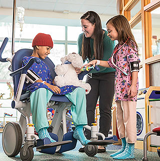Child life specialist leading a play activity with two patients