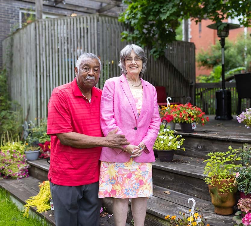 Therese McGee stands in a garden with her husband, Bob.