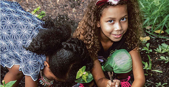 Two girls help in a community garden