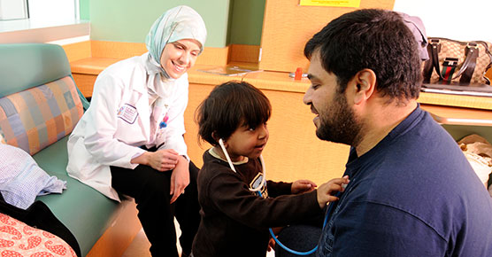 Pediatric liver transplant recipient Humaid Alsayegh playing with his family and pediatric hepatologist physician Ruba Azzam, MD.