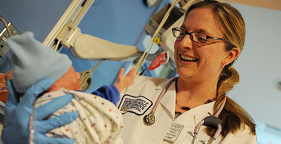 Neonatologist Bree Andrews, MD, cradling a baby boy in the NICU
