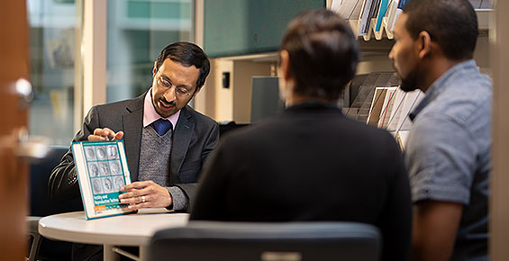 Reproductive endocrinologist Alberuni Zamah, MD, reviewing patient education materials with a couple