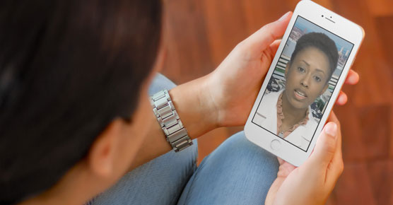 Chelsea Dorsey, MD, giving video visit on cell phone