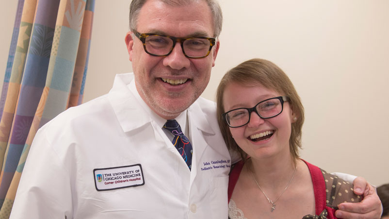 Doctor sitting on cabinet looking right, looking happy