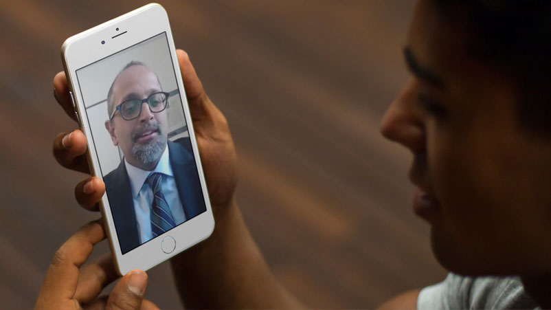 Shyam Prabhakaran, MD, giving telemedicine visit via phone with male patient
