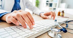 Doctor typing on computer