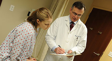 Roger D. Hurst, MD talking with a patient