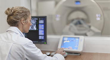 Doctor operating CT scanner in hospital