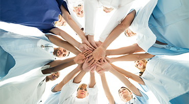 multiethnic medical team stacking hands over white background