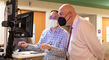 Image of John M. Cunningham, MD reviewing patient information