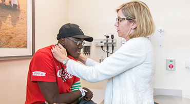 Pediatric hematologist/oncologist Tara Henderson, MD, MPH, examines a young patient