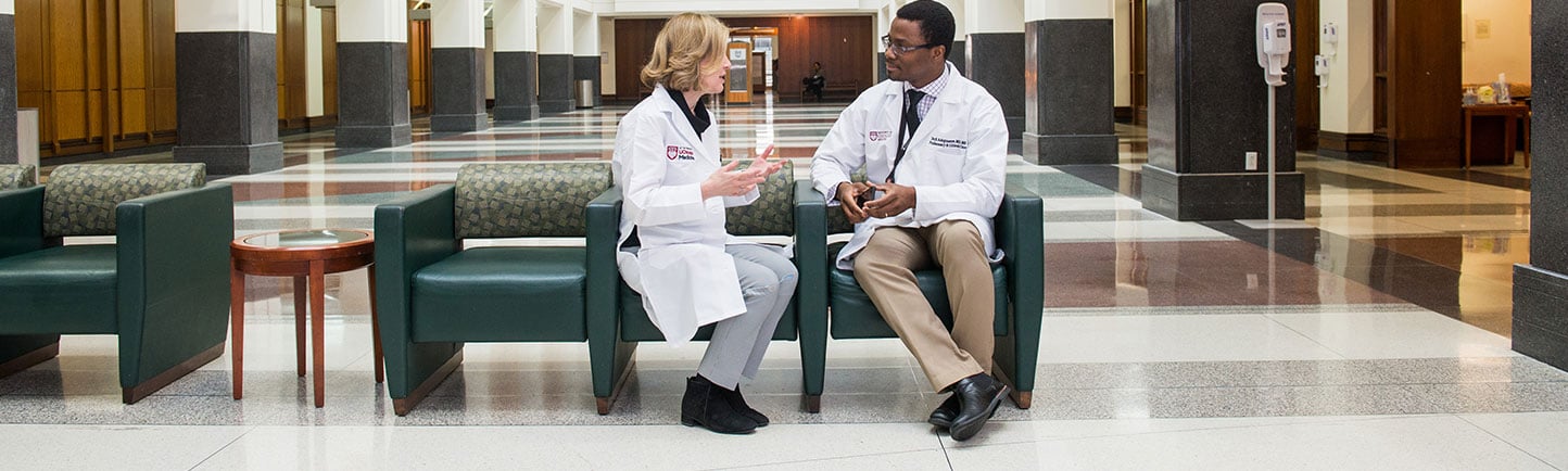 Two physicians speaking in the hospital lobby
