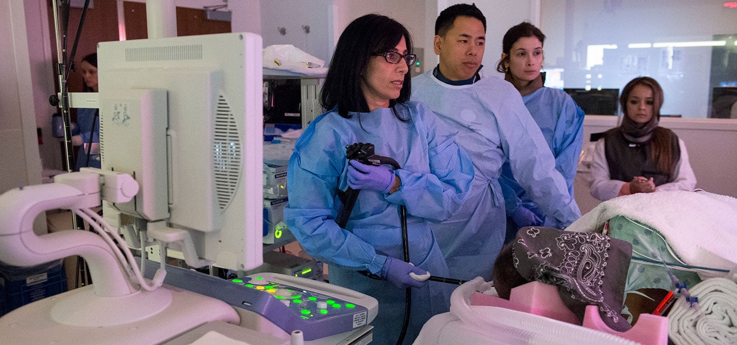 Interventional GI specialist Uzma Siddiqui, MD, left, with fellow Wesley Leung, MD, and the rest of her team in an endoscopy suite at the Center for Care and Discovery