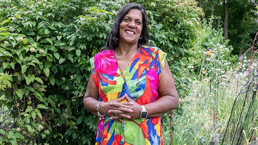 Patient Brenda Porter stands in a garden.