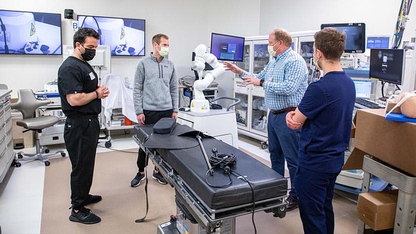 UChicago Medicine pulmonologist D. Kyle Hogarth, MD, and his team pose with the Noah Galaxy Robot, a state-of-the-art tool for bronchoscopies.