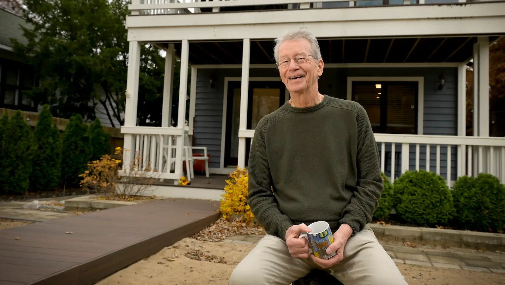 John Balogh drinking coffee in front of his home