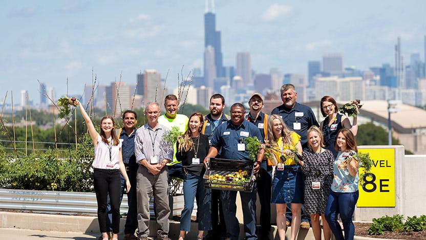 Group photo on top of parking garage with vegetable garden