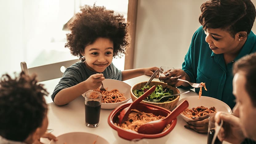 Image of family eating dinner together and smiling
