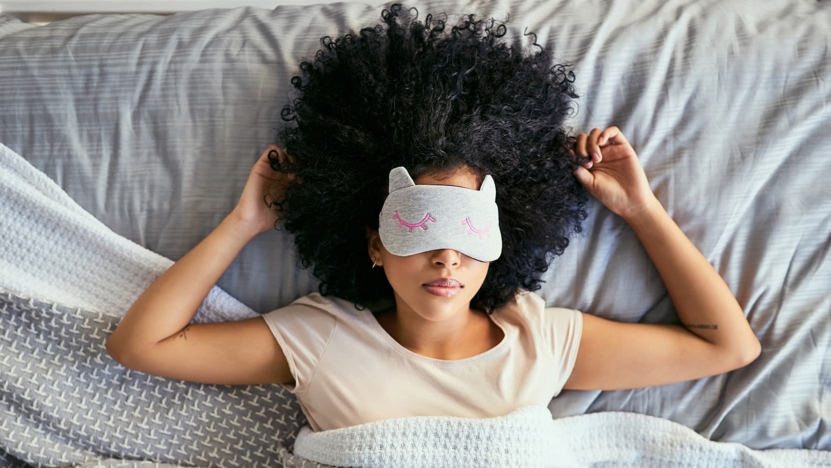woman with sleep mask in bed