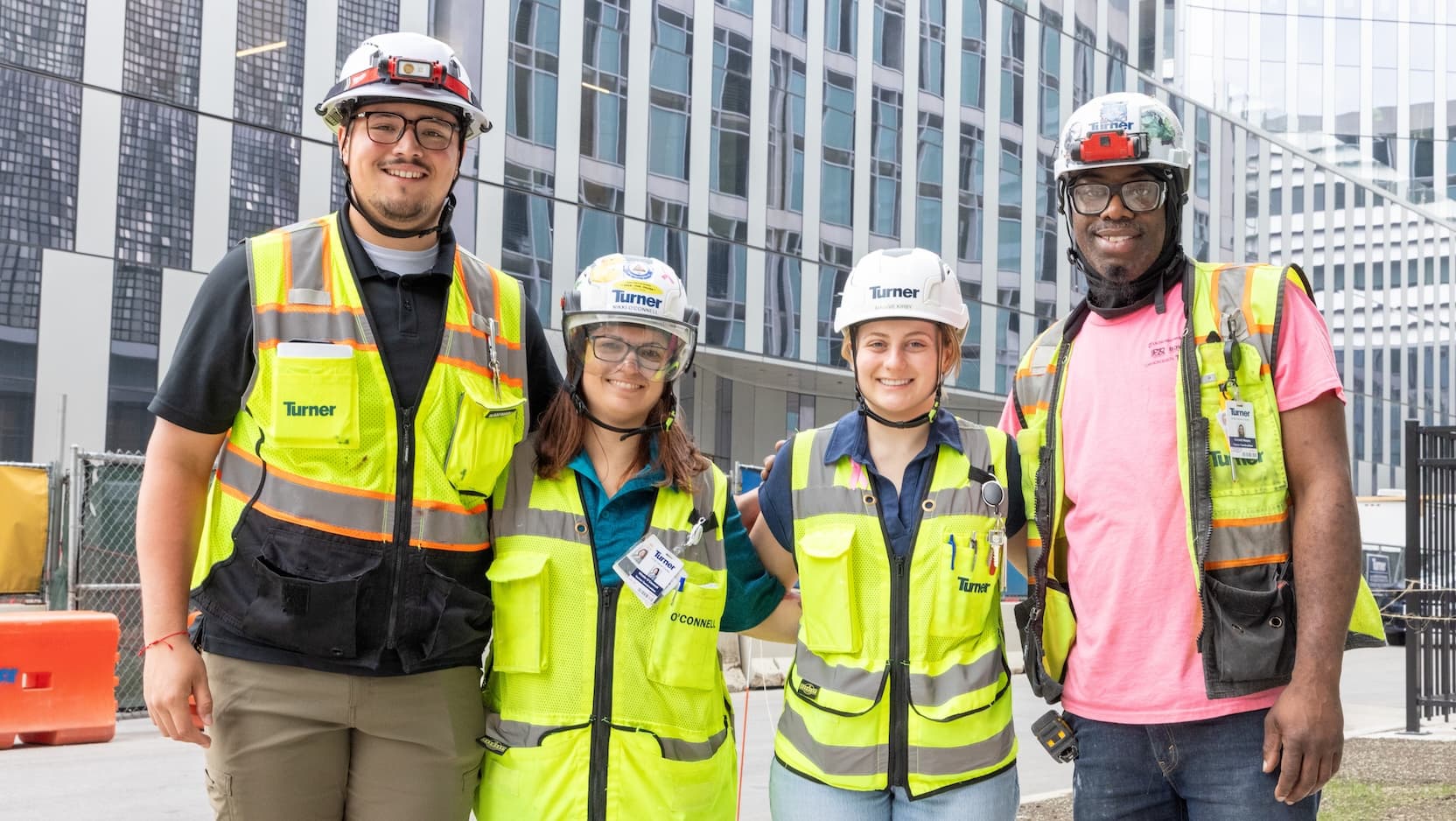 Four construction workers in front of new cancer pavillion