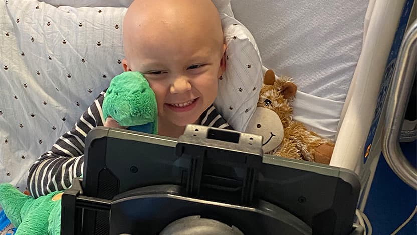Comer Children's Hospital cancer patient Alexander Brown, 4, holds his new stuffed dinosaur while getting a tour of the Field Museum's dinosaur exhibit.