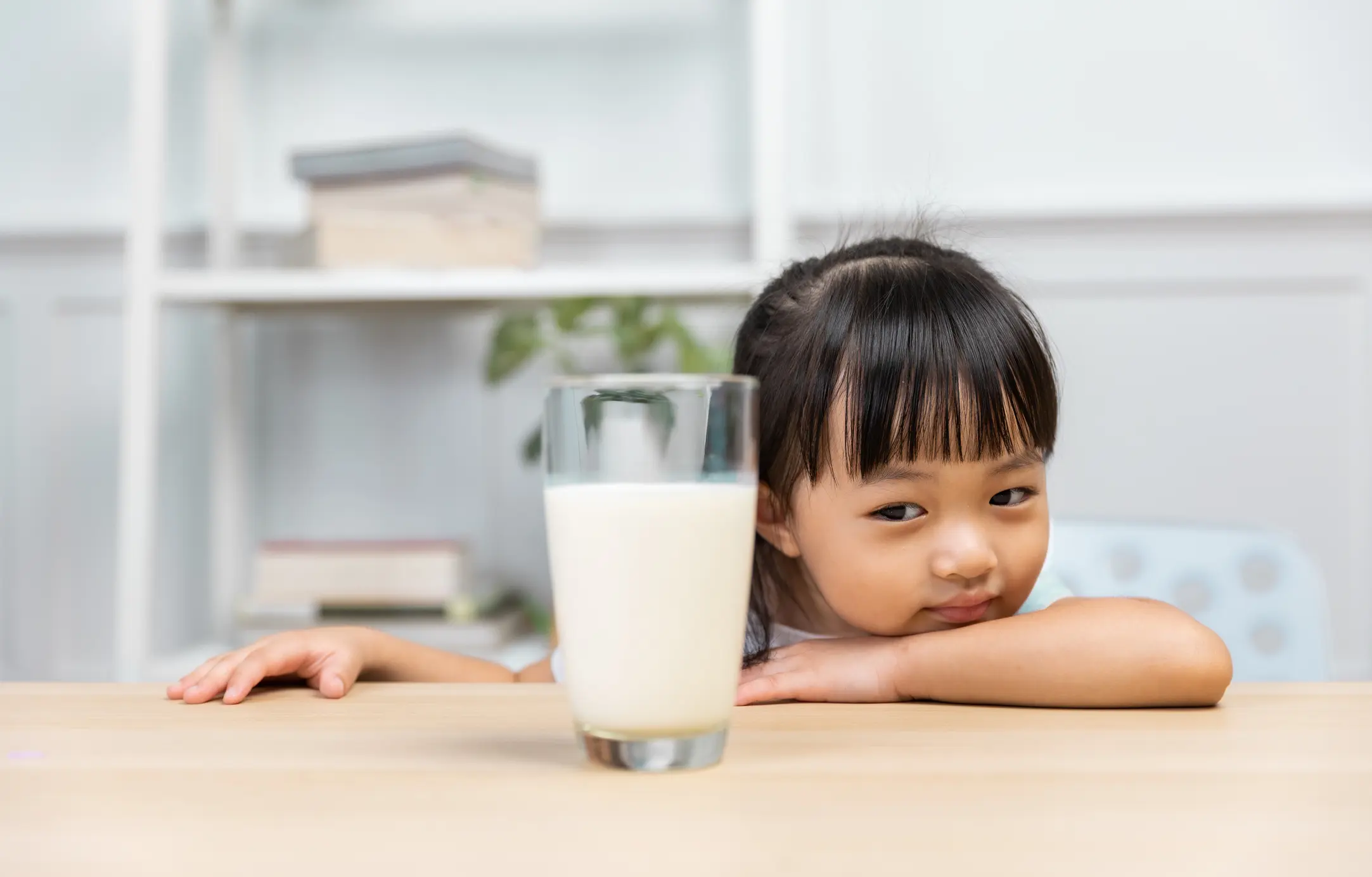 Child eyes glass of milk. Is it healthy?