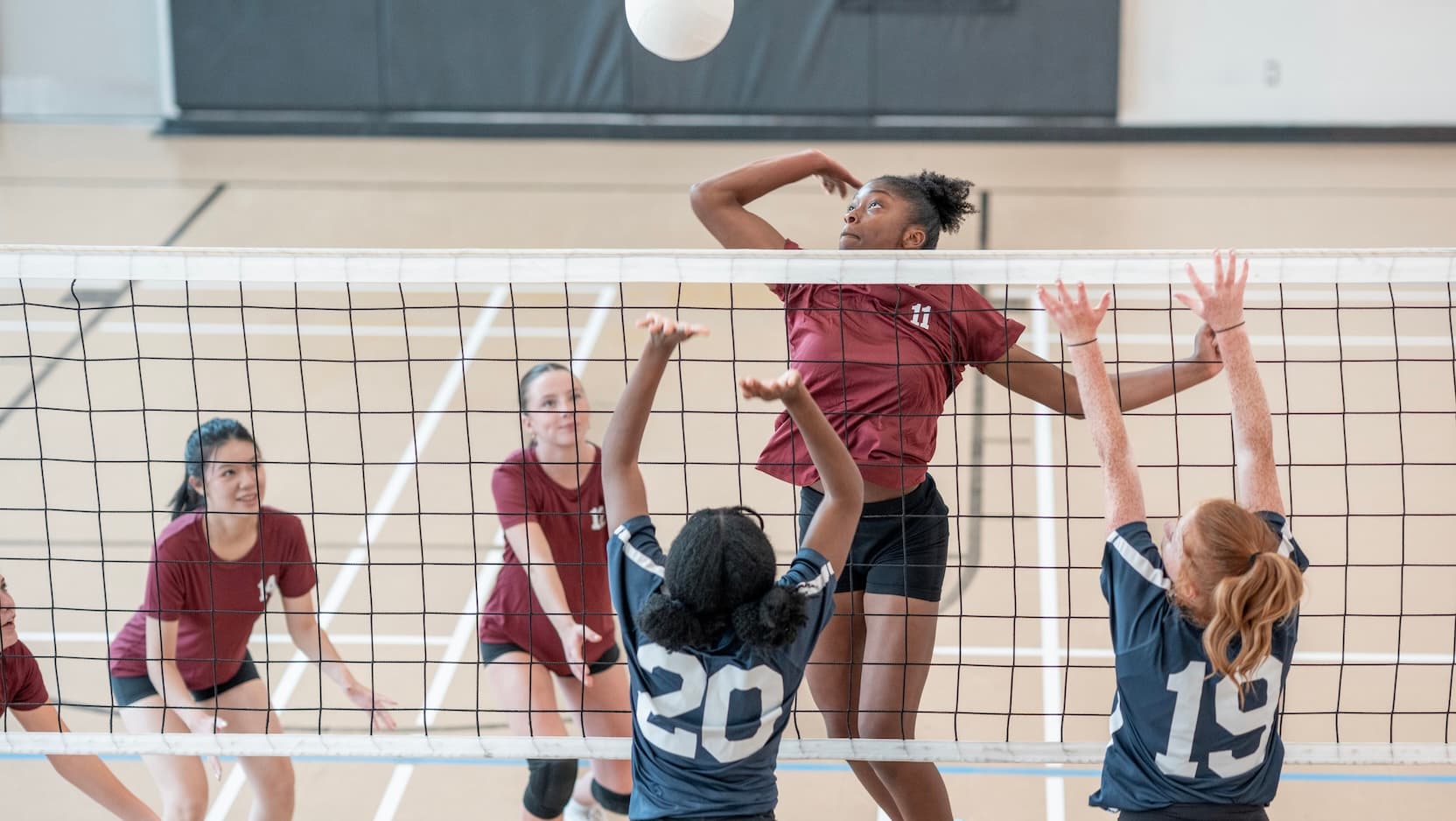 teenage girls play volleyball