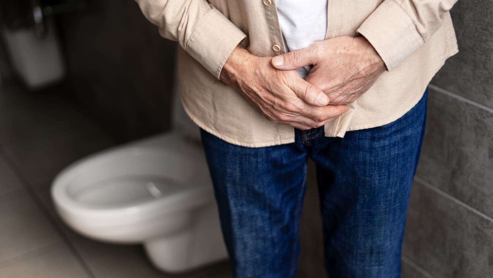 Senior man experiencing prostate problems in bathroom stock photo