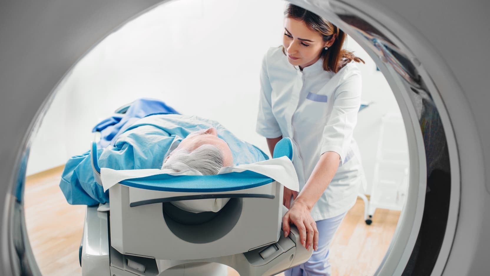 Care member assisting person receiving CT scan