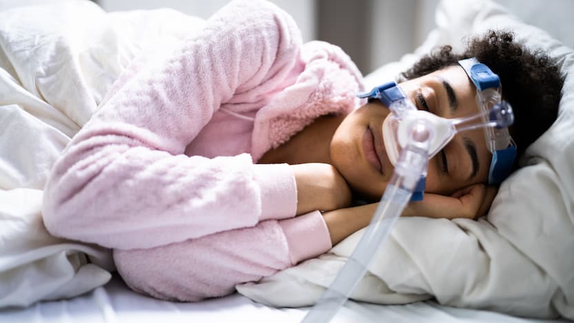 Person sleeping wearing CPAP machine
