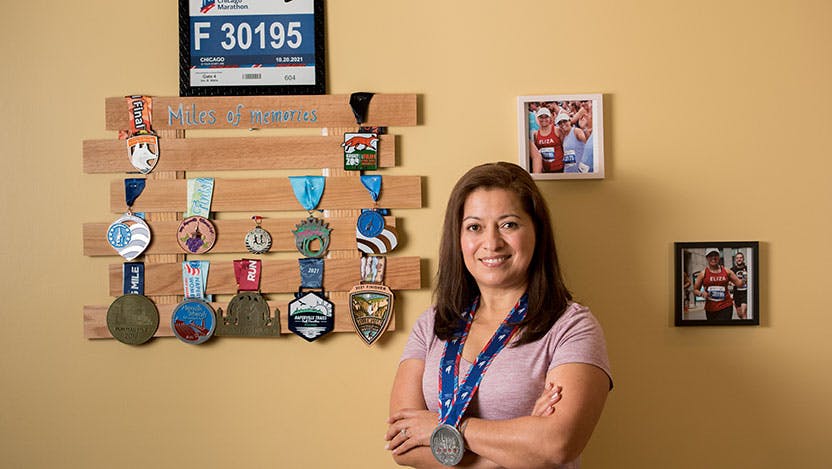Elizabeth Jimenez standing in front of marathon medals 