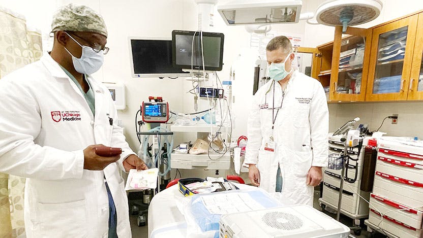 Kenneth Wilson, MD, works with Lt. Col. Timothy Plackett, DO, a trauma surgeon from the U.S. Army.