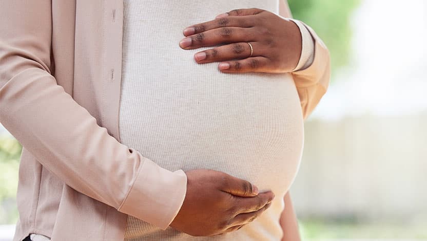 A woman's hands cupping her pregnant belly