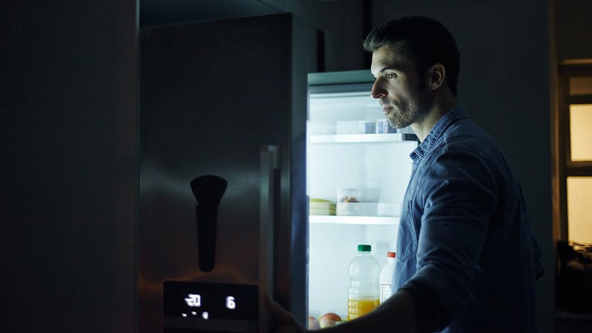 Man looking in refrigerator at night