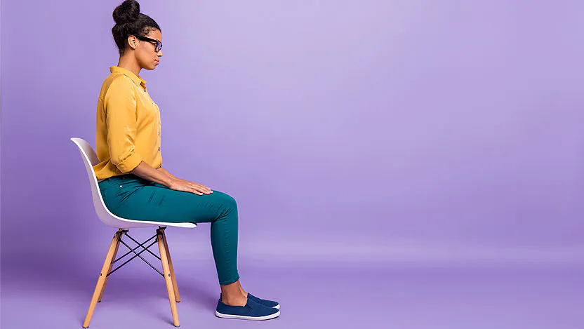 Woman sitting in chair on purple background