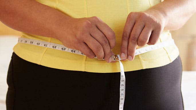woman with tape measure around her waist 