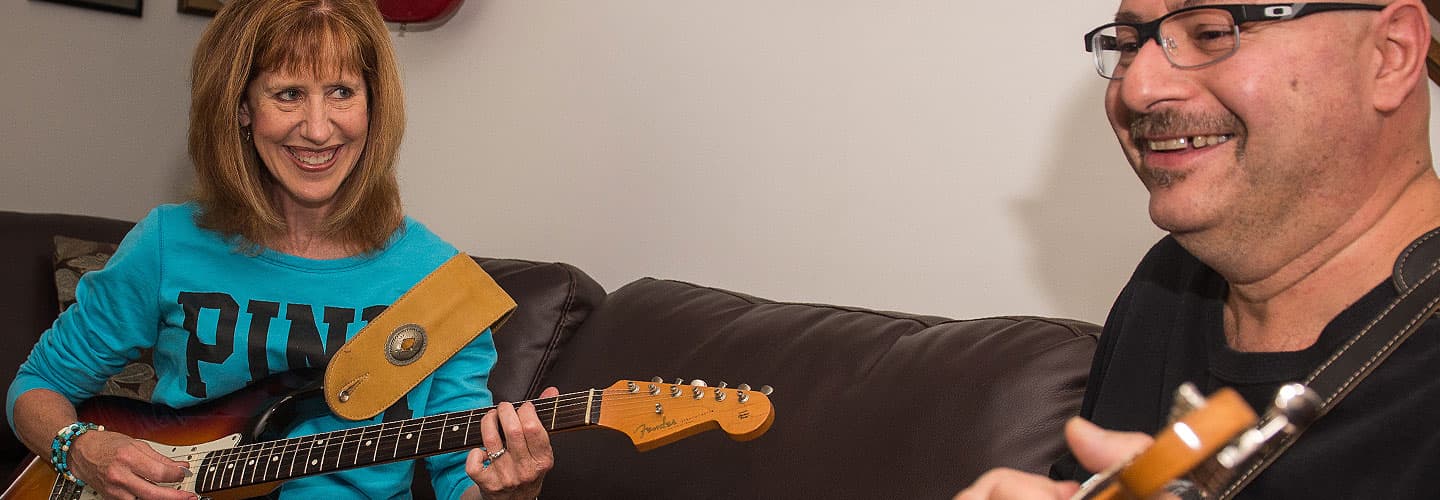 Jean Martinez playing guitar with her husband after treatment for Parkinson's tremor