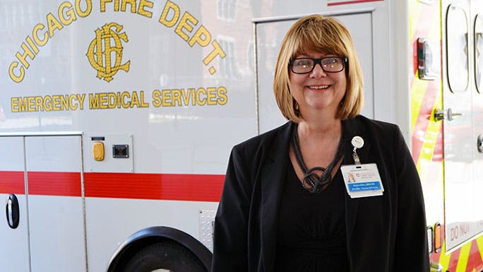 Deb Allen stands in front of an ambulance