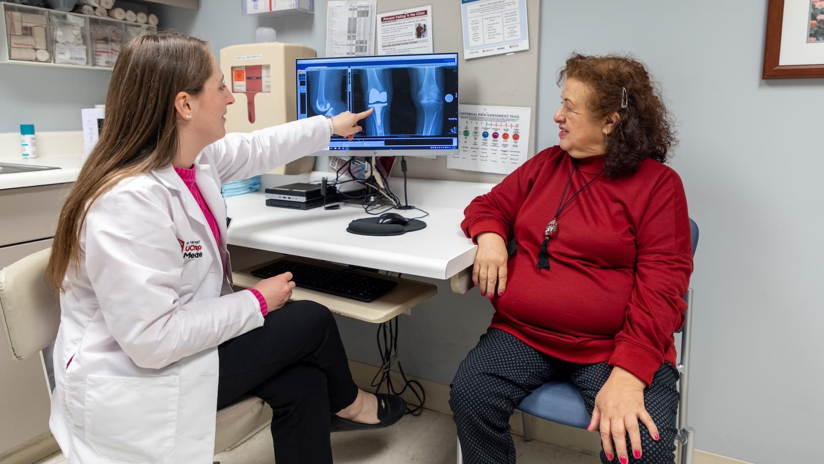 Stephanie Bachmann, MMSPA, a UChicago Medicine advance practice provider, shows Luz Graciela Gamero how care teams can monitor the progress of her new smart knee replacement.