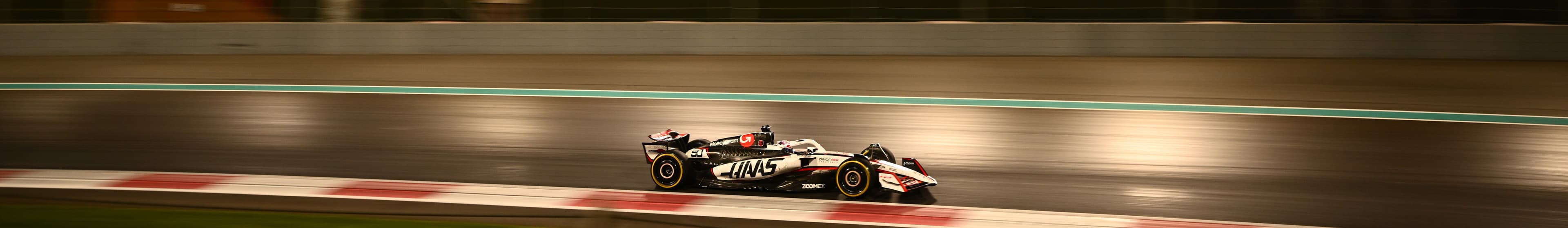 F1 racecar on a track at dusk with trees visible behind