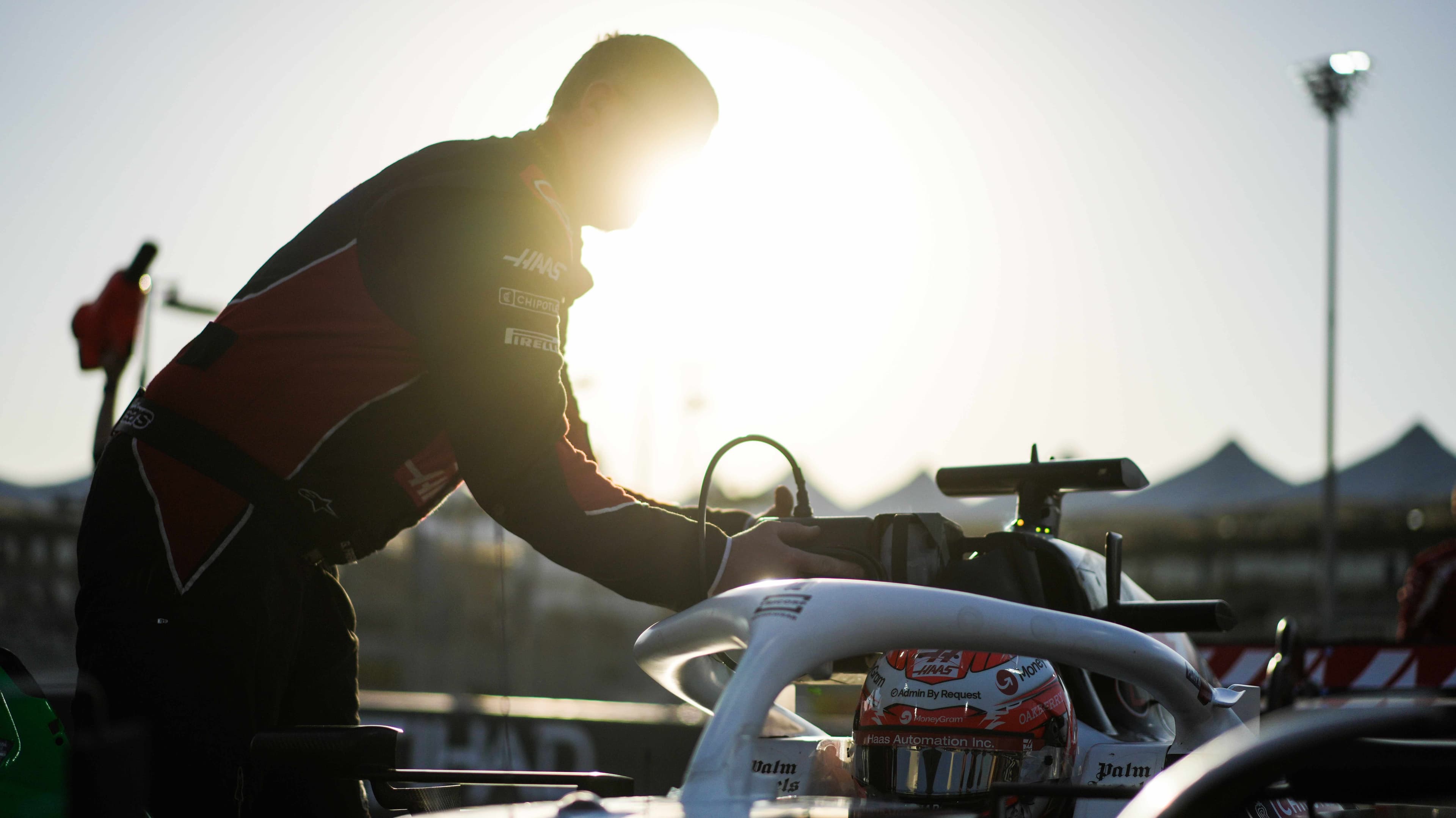 Haas racer working on their car in a sunset