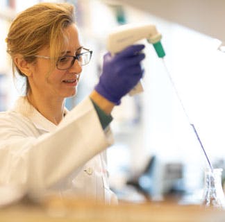 female cancer researcher with large pipette in lab