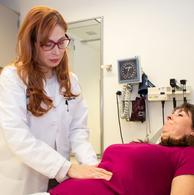 Mecker Moller, MD, examining a patient in clinic