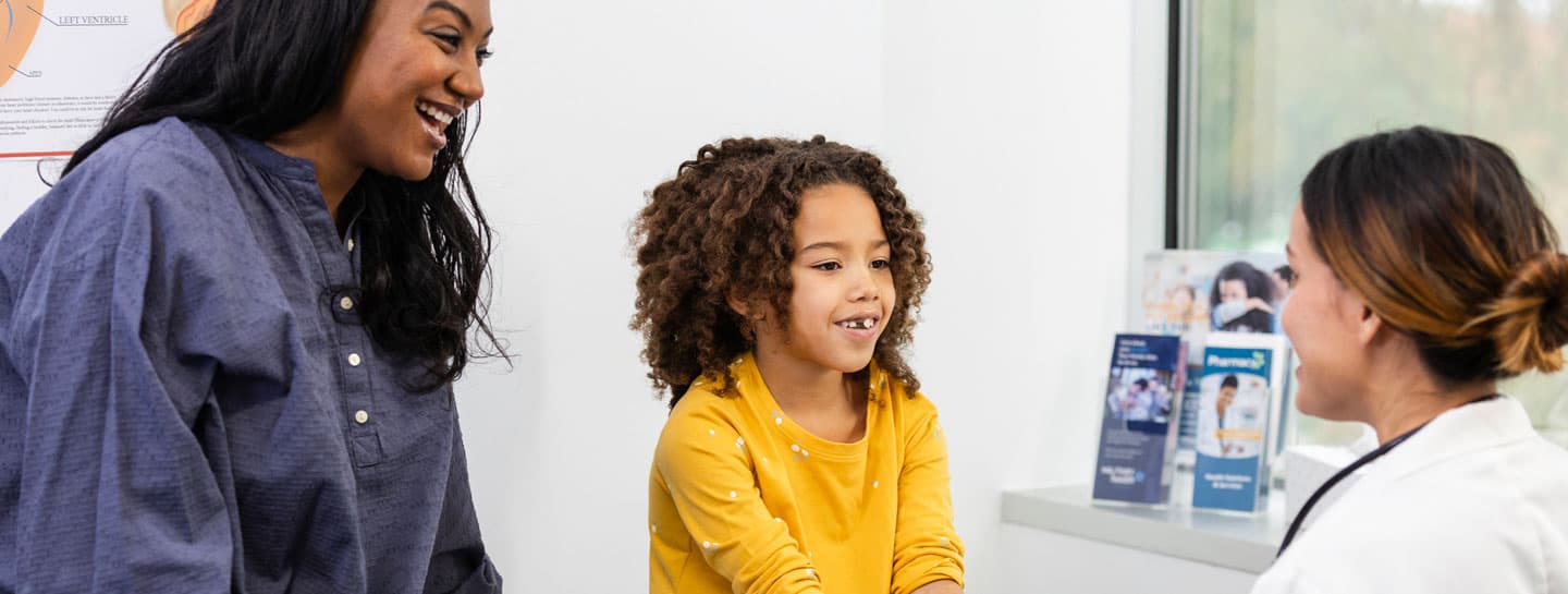 Child and mom meeting with doctor in clinic