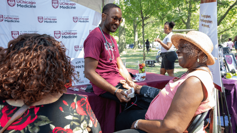 Volunteer performs a blood pressure check at a community event