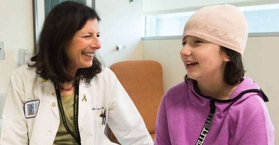 Susan Cohn, MD, pediatric oncologist, with young female patient