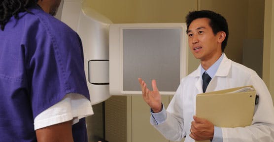 Stanley Liauw, MD, talking with staff member in radiation oncology suite