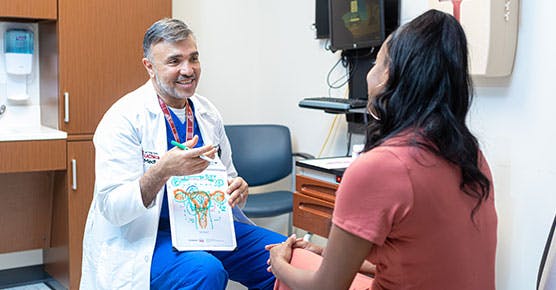 Gynecologist Ayman Al-Hendy, MD, PhD, talks with a patient