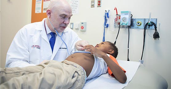 Image of Dr. Cunningham working with pediatric cancer patient