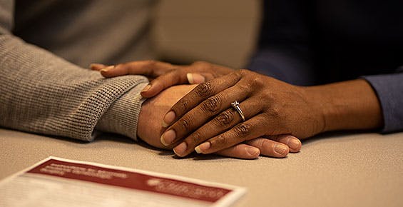 Couples' hands on desk with a patient letter nearby
